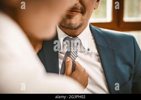 Frau richtet die Krawatte eines Mannes im Büro aus Stockfoto