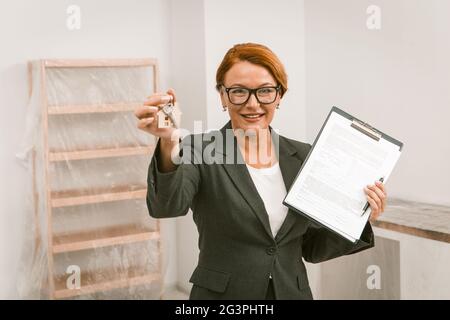 Grundstücksmakler schlägt vor, ein Abkommen über Wohnung mieten, Kamera auf Gesicht konzentriert. Stockfoto