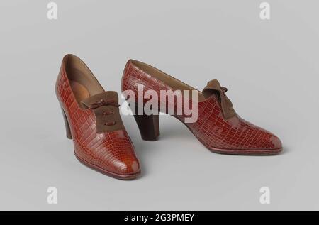 Schuh aus rotbraunem Schlangenleder mit einer Zunge aus braunem Wildleder mit einer geschnürten und strengen Lederspitze. Robe Schuh aus rot-braunem Schlangenleder mit einer Zunge aus braunem Wildleder mit einer geschnürten und strengen Lederspitze. Modell: Slipper mit hohem, geradem Absatz (7 cm). Auf dem gerieben ein elastisches Band für einfachen Einstieg. Gefüttert mit leberfarbenem Leder. Innensohle aus naturfarbenem Leder mit goldenem Druck. Ledersohle und -Absatz. Dekoration: Zur Tarnung des Gummibandes wurde eine Zunge aus doppelt genähtem Wildleder über das geriebene Band aufgetragen, die aus einem 5 cm breiten halbrunden Schnitt im Bezug stammt und verschwindet Stockfoto