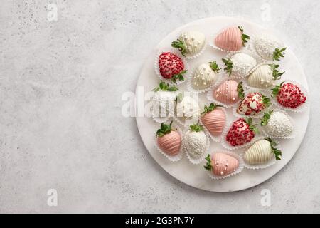 In Schokolade getauchte Erdbeeren mischen sich auf Marmorplatte, Platz zum Kopieren Stockfoto