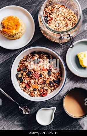 Obstgranola Cerealien Frühstücksschüssel mit Milch auf Holzhintergrund Stockfoto