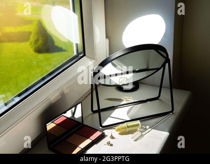 Raues Sonnenlicht, das durch das Fenster direkt in den Spiegel kommt, was zu einer Brandgefahr im Heimkonzept führen kann. Stockfoto
