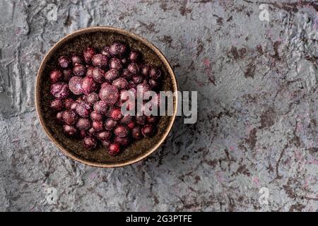 Schüssel mit gefrorenen Blaubeeren auf strukturierter Oberfläche Stockfoto