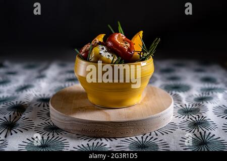 Dunkle Fotografie von mit Frischkäse gefüllten Kirschpaprika. Mediterrane Sommervorspeise auf Serviette. Stockfoto