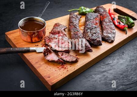 Barbecue Wagyu Rock Beef Steak mit scharfem Chili und würziger BBQ Sauce als Nahaufnahme auf Holzdesign Board angeboten Stockfoto