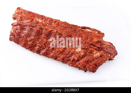 Rohe Schweinelende Rippen St. Louis geschnitten mit würzigem Reib als Nahaufnahme auf weißem Hintergrund mit frei wählbaren Kopierflächen angeboten Stockfoto