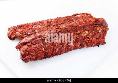 Rohe Schweinelende Rippen St. Louis geschnitten mit würzigem Reib als Nahaufnahme auf weißem Hintergrund mit frei wählbaren Kopierflächen angeboten Stockfoto