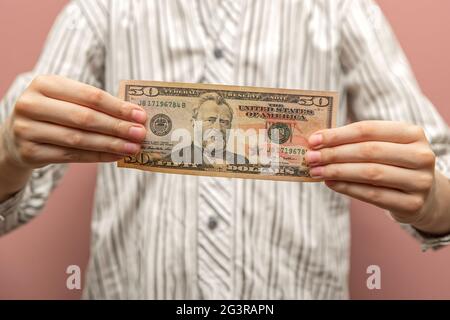 Geldhilfe für das Kind. Fünfzig Dollar in den Händen eines Kindes als Konzept der finanziellen Unterstützung für Kinder, Zahlung von Unterhaltszahlung, Investitionen.Ph Stockfoto