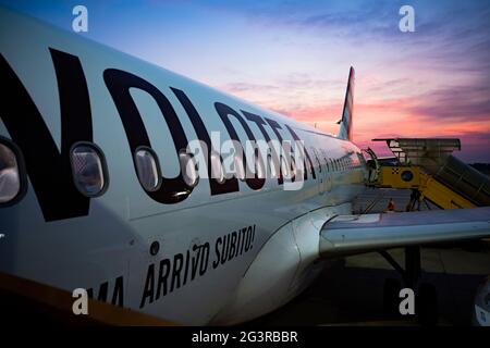 Ein Verkehrsflugzeug, das bei einem atemberaubenden Sonnenuntergang die Passagiere vom Flughafen Verona an Bord nehmen kann. Stockfoto