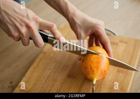 Frische, reife Bio-Granadilla oder gelbe Passionsfrucht, halbiert auf einem Holzbrett. Exotische Früchte, gesunde Ernährung Konzept Stockfoto