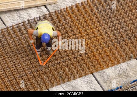 Arbeiter, die auf einer Baustelle (Gebäude) eine Schneidzange zum Schneiden des Verstärkungsstahls verwendeten Stockfoto