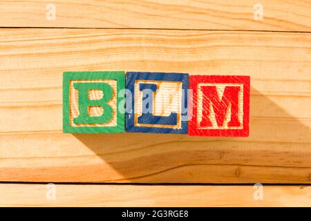 Spektakuläre Holzwürfel mit dem Wort BLM BLACK LIVES MATTER auf einer Holzoberfläche. Stockfoto