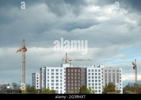 Bau eines mehrstöckigen Gebäudes. Modernes Hochhausgebäude. Wohngebiet. Krane bauen mehrstöckige Gebäude. Hochwertige Fotos Stockfoto