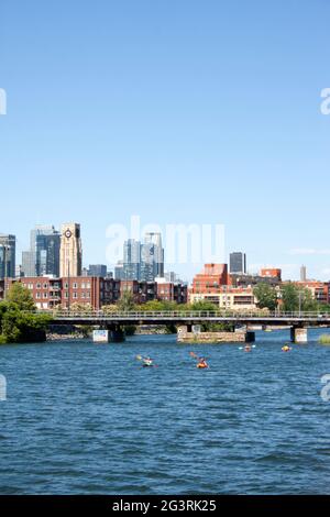 Blick auf die Innenstadt von Montreal und den Atwater Market vom Lachine Canal aus mit Booten und Kajaks, die entlang schwimmen Stockfoto