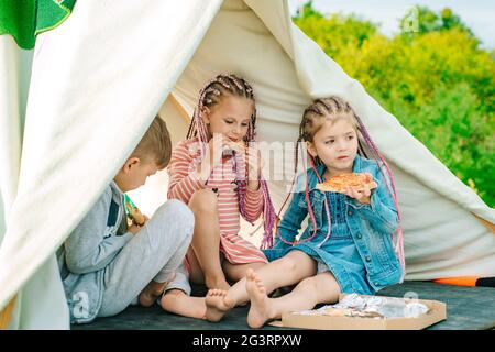 Kinder Freunde essen leckere Pizza. Kinder lieben Essen. Fastfood für Kinder. Kinder essen Pizza. Italienisches Junkfood. Stockfoto