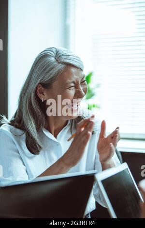 Asiatische Frau lachend bei Geschäftstreffen Stockfoto