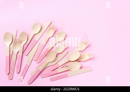 Einweg-Bambuslöffel, Gabeln und Messer auf rosa Hintergrund. Zero Waste Konzept. Draufsicht, Kopierbereich. Stockfoto