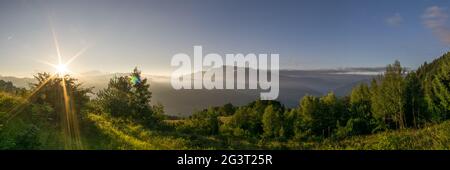 Panorama des friedlichen Morgens mit Sonnenaufgang über den französischen alpen mit Wiese im Vordergrund Stockfoto