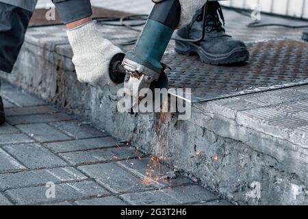 Bearbeitung des Blechs mit einem Winkelschleifwerkzeug Stockfoto