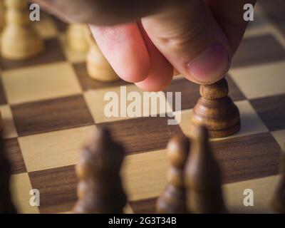 Person, die einen Bauer während eines Schachspiels bewegt Stockfoto