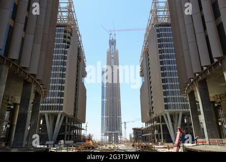 Neue Verwaltungshauptstadt, Ägypten. Juni 2021. Das Foto vom 17. Juni 2021 zeigt, dass der ikonische Turm (C) auf der Baustelle des Projekts des zentralen Geschäftsviertels (CBD) in der neuen Verwaltungshauptstadt Ägypten gekrönt wird. Mit einem beeindruckenden Blick auf die modernen Gebäude, die im zentralen Geschäftsviertel (CBD) der neuen ägyptischen Verwaltungshauptstadt entstehen, hielten Gäste aus China und Ägypten am Donnerstag eine Richtungszeremonie für den 385 Meter hohen, ikonischen Turm ab, der nach der Fertigstellung das höchste Gebäude Afrikas sein wird. Quelle: Sui Xiankai/Xinhua/Alamy Live News Stockfoto