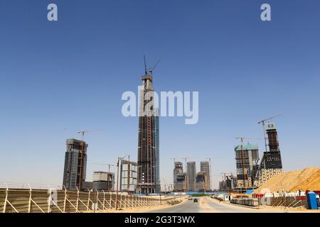 Neue Verwaltungshauptstadt, Ägypten. Juni 2021. Das Foto vom 17. Juni 2021 zeigt, dass der ikonische Turm (C) auf der Baustelle des Projekts des zentralen Geschäftsviertels (CBD) in der neuen Verwaltungshauptstadt Ägypten gekrönt wird. Mit einem beeindruckenden Blick auf die modernen Gebäude, die im zentralen Geschäftsviertel (CBD) der neuen ägyptischen Verwaltungshauptstadt entstehen, hielten Gäste aus China und Ägypten am Donnerstag eine Richtungszeremonie für den 385 Meter hohen, ikonischen Turm ab, der nach der Fertigstellung das höchste Gebäude Afrikas sein wird. Quelle: Sui Xiankai/Xinhua/Alamy Live News Stockfoto