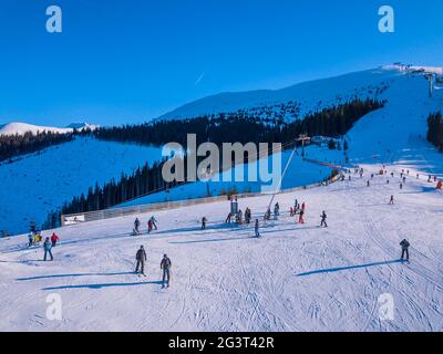 Skifahrer auf der Skipiste an einem sonnigen Wintertag. Luftaufnahme Stockfoto