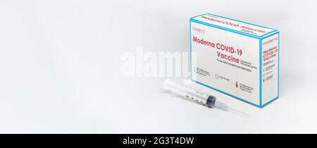 Cambridge, MA, USA, februar 5th 2021: Eine Spritze neben der Impfstoffdose Moderna Covid-19, isoliert auf weißem Hintergrund. Gesundheit und Prävention. Stockfoto