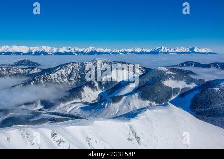 Schneebedeckte Gipfel und Morgenmist Stockfoto