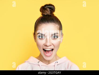 Emotional überrascht Frau Gesicht Nahaufnahme Porträt auf gelbem Hintergrund. Stockfoto