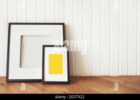 Zwei Plakate auf dem Holzboden an der weißen Wand Stockfoto