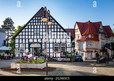 BUNDE, DEUTSCHLAND. 12. JUNI 2021. DeLaCasa Restaurant auf dem Platz, rosa Fahrrad vor dem Eingang mit Werbung für Bienenhaus Land Frauen. Wunderschönes V Stockfoto