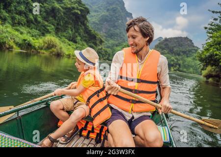 Glückliche Familien-Touristen in Trang an Scenic Landscape Complex in Ninh Binh Provinz, Vietnam EIN UNESCO-Weltkulturerbe. Wiederaufnahme des Tourismus in Stockfoto