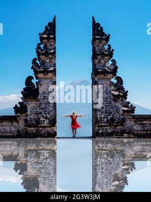 Reisende Frau, die an den alten Toren des Pura Luhur Lempuyang Tempels, auch bekannt als Tore des Himmels, auf Bali steht Stockfoto