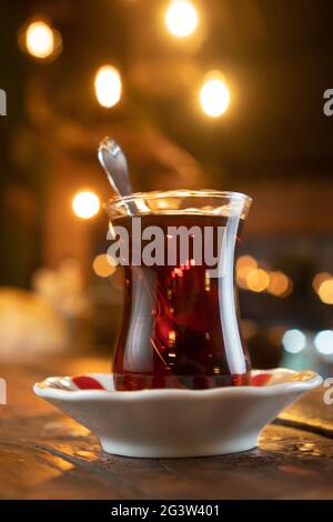 Ein Glas türkischen Tees auf einem rustikalen Holztisch Stockfoto