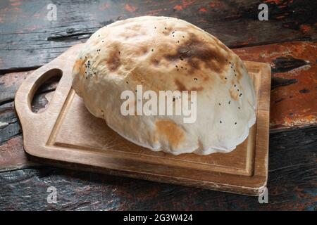 Traditionelles türkisches Brot auf rustikalem Holztisch Stockfoto