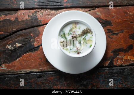 Türkische Yayla- oder Joghurtsuppe mit Minzsauce (Tzatziki) auf rustikalem Holztisch Stockfoto