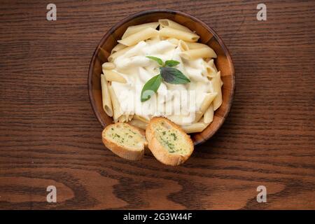 Vier Käse-Pasta mit Knoblauchbrot auf Holzhintergrund Stockfoto