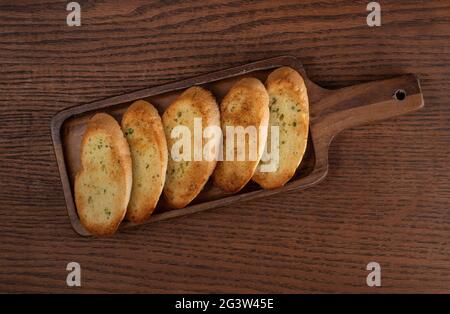 Geröstete Baguette-Scheiben auf rustikalem Holzküchentisch Stockfoto