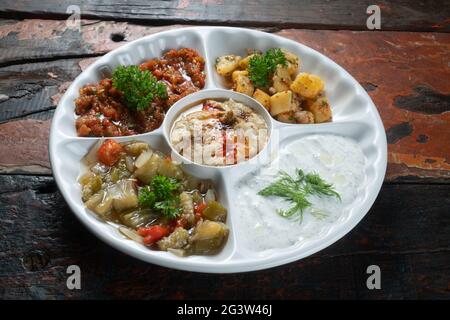 Mischen Sie arabische Speisen auf einem Teller mit vegetarischen Vorspeisen auf rustikalem Holzhintergrund Stockfoto