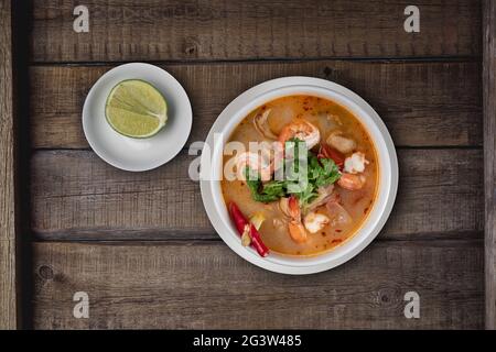 Draufsicht Thailändisches Essen Tom Yum Suppe mit Garnelen auf rustikalem Holztisch Stockfoto