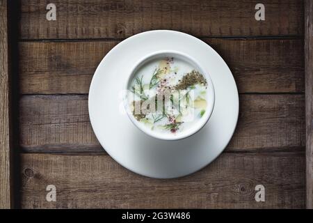 Türkische Yayla- oder Joghurtsuppe mit Minzsauce (Tzatziki) auf rustikalem Holztisch Stockfoto