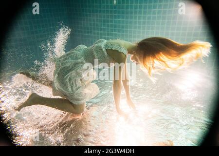 Schöne Frau unter Wasser in weißem Kleid Stockfoto