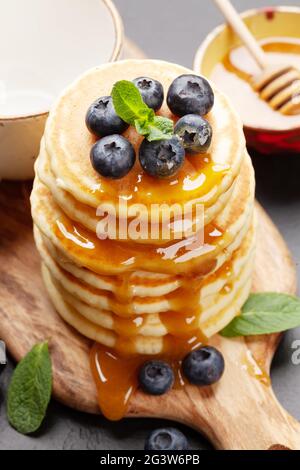 Gesundes Frühstück mit Pfannkuchen. Hausgemachte amerikanische Pfannkuchen mit Beeren und Honig Stockfoto