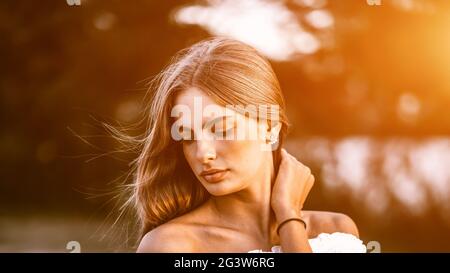 Nahaufnahme Porträt eines schönen Mädchen mit gesunden Haaren vom Wind geblasen genießen ihre Zeit im Freien im Park mit dem Sommer Stockfoto