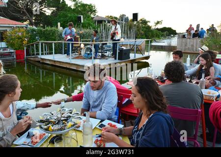 GIRONDE (33). ARCACHON BAY. KAPPENFERRET. MUSIKALISCHES ABENDESSEN IM CABANE DU MIMBEAU. Stockfoto