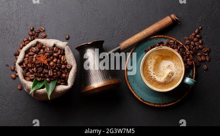 Geröstete Kaffeebohnen, türkischer Jezve und Espresso-Kaffeetasse. Draufsicht flach liegend Stockfoto