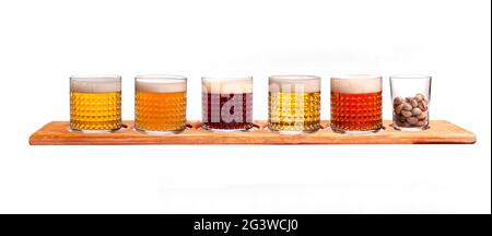 Fünf verschiedene Biersorten auf einem Holzständer. Dunkles Bier, helles, ungefiltertes, rotes Bier, dunkles irisches Ale Stockfoto