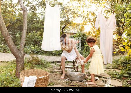 Mutter und Tochter hängen Wäsche im Hinterhof Stockfoto