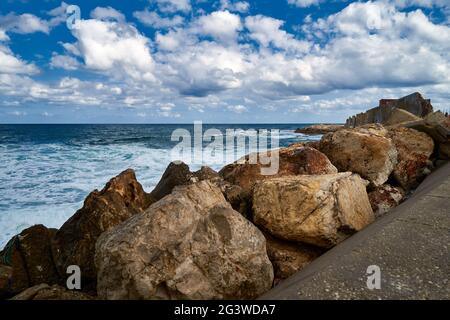 Der Blick auf das Meer mit dem bewölkten Himmel. Horizont und Steine an der Küste. Stockfoto